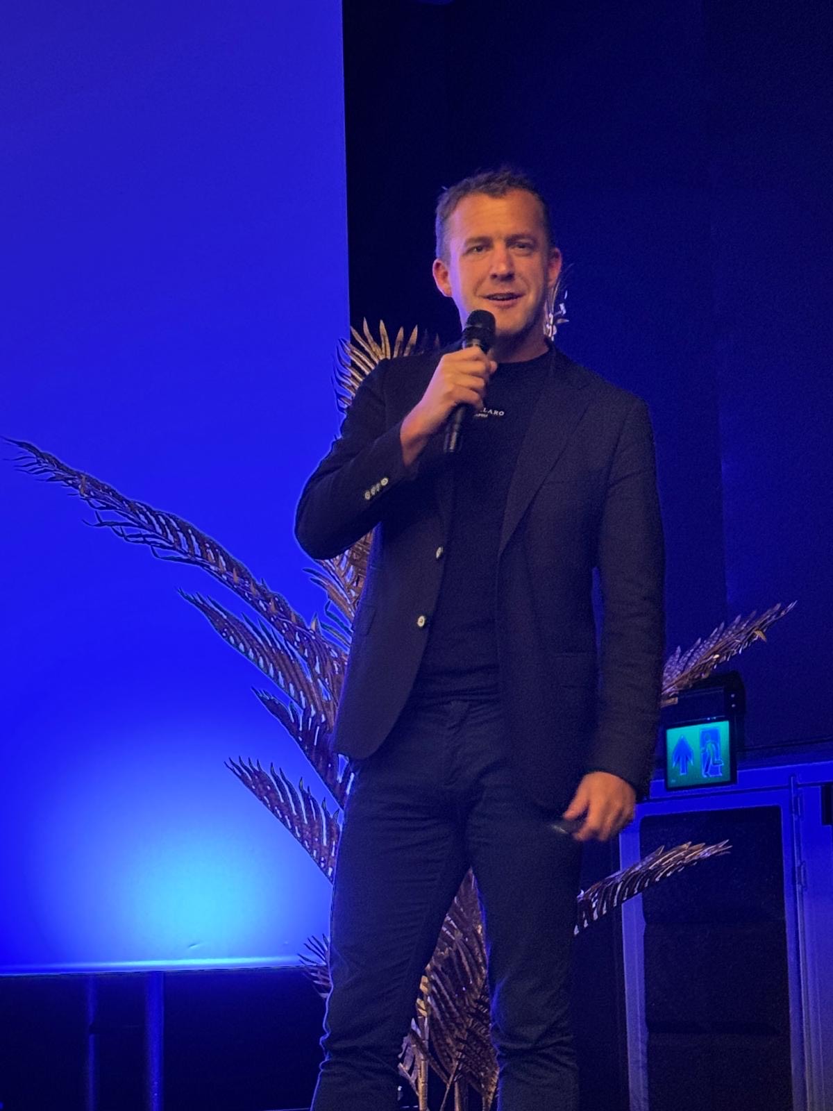 Tom de Haan spreekt op podium